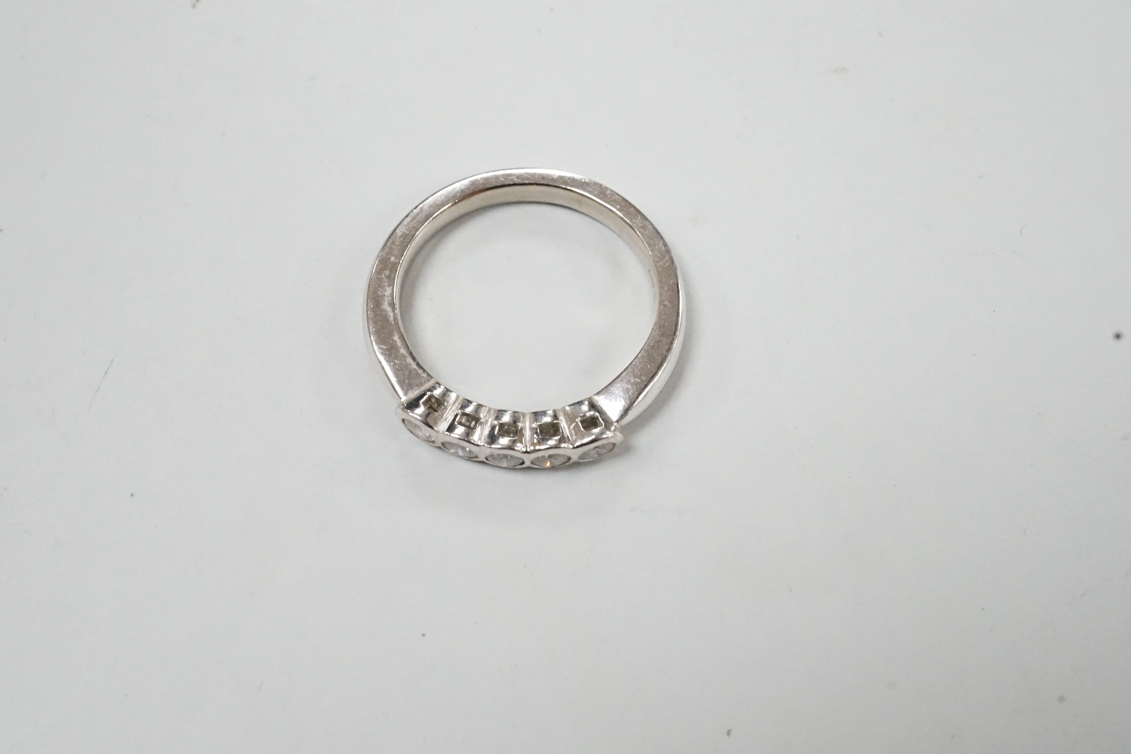 A modern 18ct white gold and five stone collet set diamond ring, size M, gross weight 5 grams.